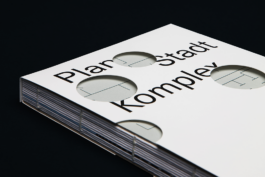Schober des Buches Plan Stadt Komplex liegend auf schwarzem Hintergrund.